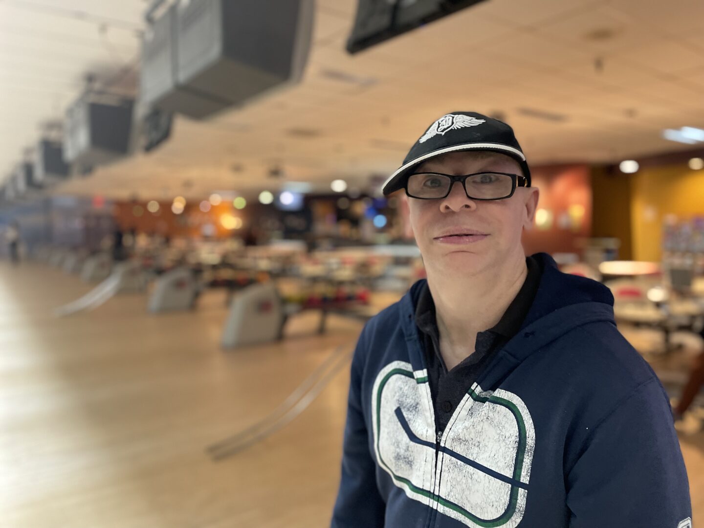 Erol wearing a sweater and hat and glasses