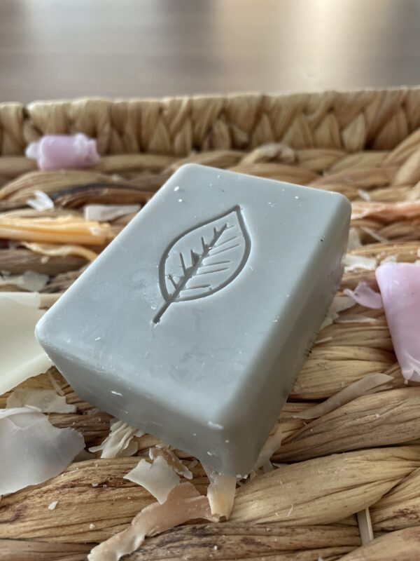 Grey bar of soap with leaf on it