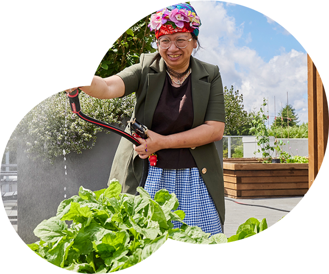 Layer_1 Smiling woman watering vegetable garden